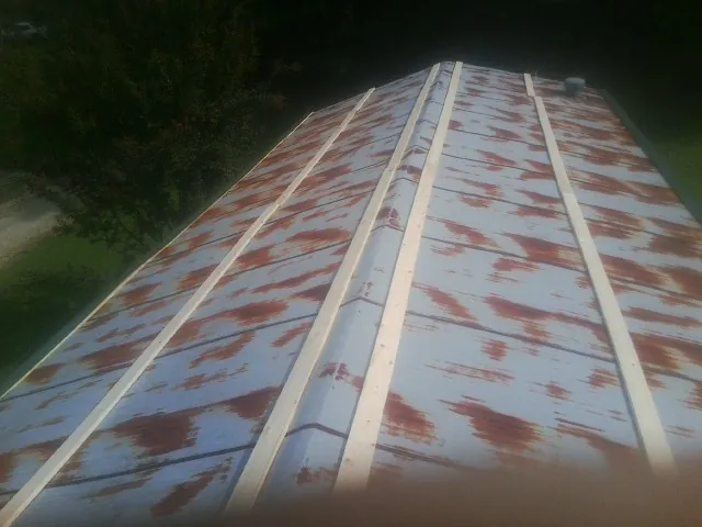 Rusted metal roof panels with new wood purlins before replacement — Storm Damage Roof Repair in Marcellus by Roofing Brothers