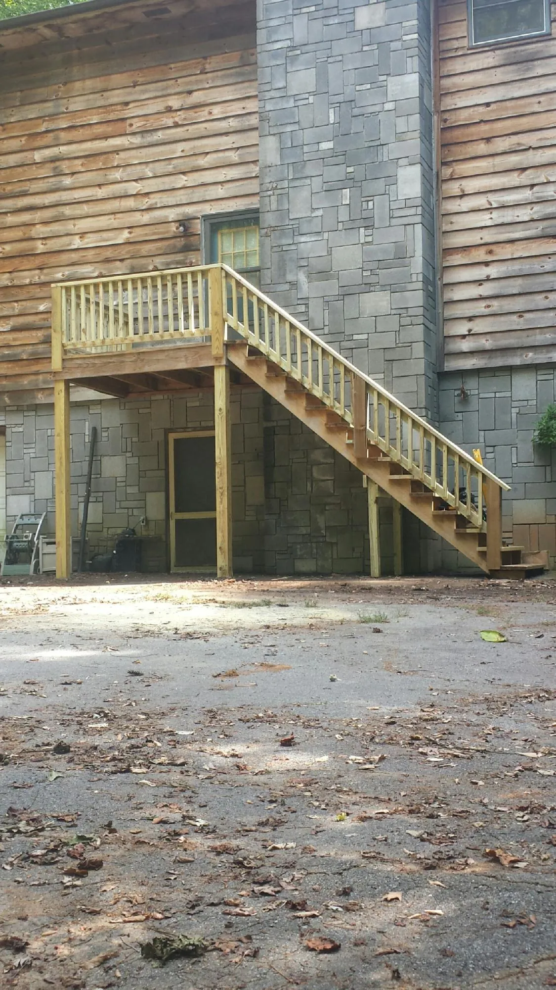 New pressure treated deck and stair landing on a log home in Marcellus