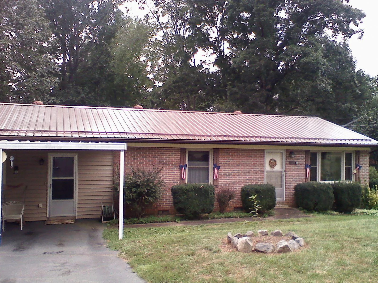 Bronze metal roof and carport on a brick ranch home — Roof Repair work by our crew in Marcellus